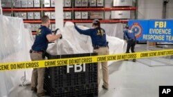 FILE: FBI special agents assigned to the evidence response team process material recovered from the high altitude balloon recovered off the coast of South Carolina, Feb. 9, 2023, at the FBI laboratory in Quantico, Va. Now China has accused the US of sending spy balloons over it.