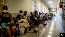 Des gens font la queue pour se faire vacciner contre le COVID-19, à l'hôpital Lenasia South, près de Johannesburg, en Afrique du Sud, le 1er décembre 2021.