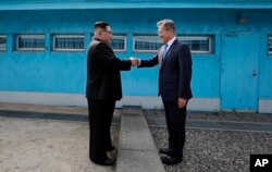27일 문재인 한국 대통령과 김정은 븍힌 국무위원장이 판문점 군사분계선에서 처음 만나 악수를 하고 있다.