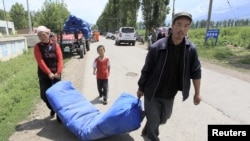 Uighur residents carry a temporary tent being distributed by the rescue team after an earthquake, in Nalati township, Xinjiang Uighur Autonomous Region June 30, 2012. 