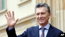 FILE - Argentina's President Mauricio Macri waves at journalists at the end of a welcoming ceremony at the Presidential Palace in Bogota, Colombia, June 15, 2016.