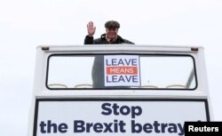 FILE - Brexit campaigner Nigel Farage gestures during a "Brexit Betrayal" march from Sunderland to London, in Sunderland, Britain, March 16, 2019.