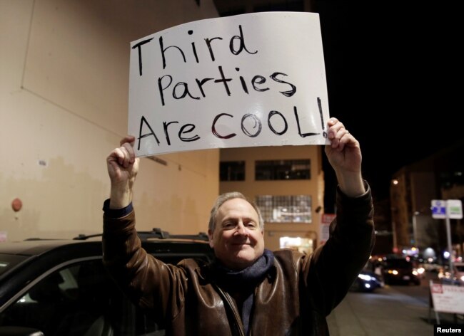 Libertarian Jeff Jared of Kirkland, Wash.,holds a sign in support of third parties before former Starbucks CEO Howard Schultz speaks during his book tour in Seattle, Jan. 31, 2019.