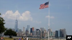 FILE - Tourists view the New York City skyline from Ellis Island, July 29, 2015, in New York. The island, situated in New York harbor, served as an entry point for immigrants to the U.S. from 1892 through 1954.