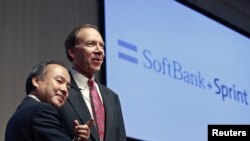 Chủ tịch Softbank Corp Masayoshi Son (trái) bắt tay với ông Dan Hesse, chủ tịch và giám đốc điều hành của Tổng công ty Sprint Nextel, tại một cuộc họp báo chung ở Tokyo, ngày 15/10/2012