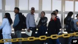 Migrants wait in line for US agents to examine their documents requesting an appointment to apply for asylum, at the Paso del Norte international bridge, in Ciudad Juarez, Mexico, Nov. 1, 2024. 