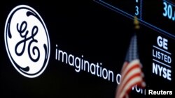 FILE - The ticker and logo for General Electric Co. is displayed on a screen at the post where it's traded on the floor of the New York Stock Exchange (NYSE) in New York City, June 30, 2016. 