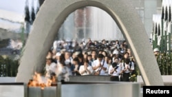 People pray in front of the cenotaph for the victims of the 1945 atomic bombing at Peace Memorial Park in Hiroshima, western Japan, in this photo taken by Kyodo, Aug. 6, 2016.