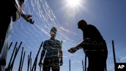 FILE - Gillnetters repair a net near the mouth of the Columbia River in Astoria, Ore.