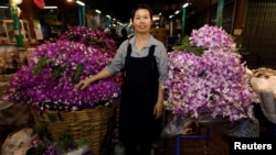 Ram, 46, poses for a photograph at her stall at the flower market in Bangkok, Thailand, Feb. 26, 2017.