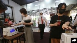Cristianos con máscaras sanitarias escanean un código en sus celulares antes de un servicio en la iglesia Yoido Full Gospel, en Seúl, Corea del Sur, el domingo 5 de julio de 2020.