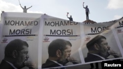 Supporters of President Mohamed Morsi carry a banner with his pictures during a protest to counter anti-Morsi protests elsewhere in Alexandria, July 2, 2013. 