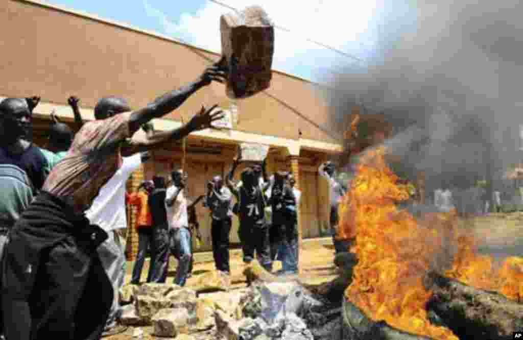 Demonstrators pile stones and set fire to block a road during a protest against the arrest of opposition leaders in Kireka suburb of the capital Kampala, April 18, 2011. Ugandan opposition leader Kizza Besigye and a number of associates were arrested as t