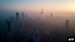 This overhead photo shows the sun rising above the skyline of Shanghai on a polluted day on February 23, 2018. (AFP PHOTO / Johannes EISELE)