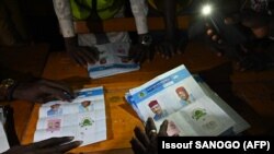 Des agents de la Commission électorale du Niger comptent les bulletins de vote dans un bureau de vote lors du second tour de l'élection présidentielle à Niamey, le 21 février 2021.