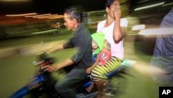 Warga yang panik karena gempa di Aceh Selasa (22/1) meninggalkan rumah dengan sepeda motor. (AP/Heri Juanda)