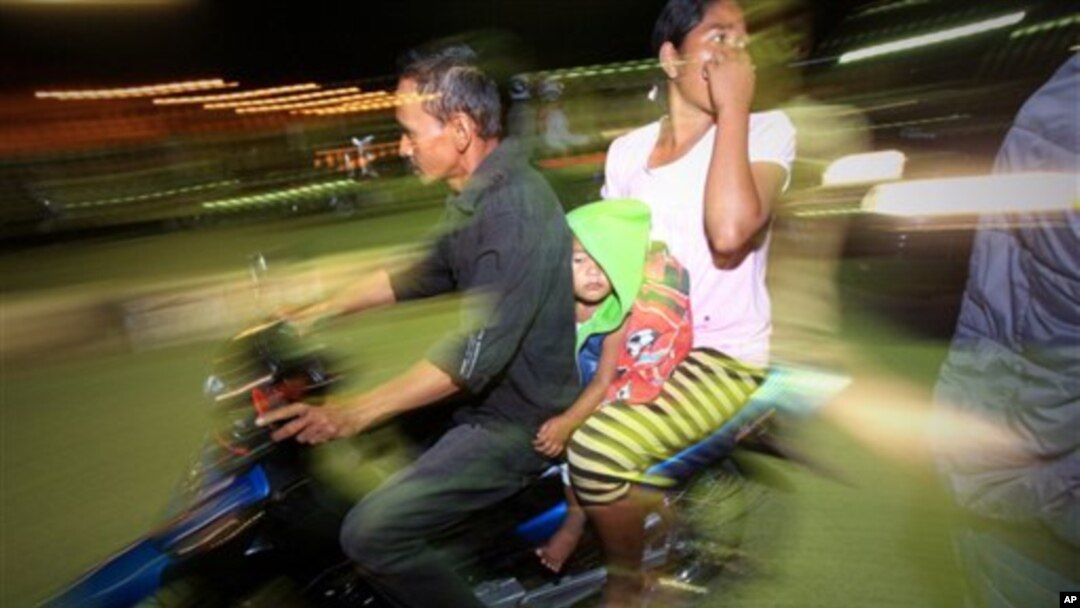 Warga yang panik karena gempa di Aceh Selasa (22/1) meninggalkan rumah dengan sepeda motor. (AP/Heri Juanda)