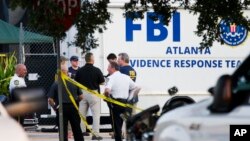 Law enforcement officials gather outside the Pulse nightclub, the scene of Sunday's mass shooting, June 15, 2016, in Orlando, Fla. (AP Photo/David Goldman)