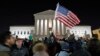 FILE - a protester waves an American flag in front of the Supreme Court during a protest about President Donald Trump's recent executive orders in Washington. 