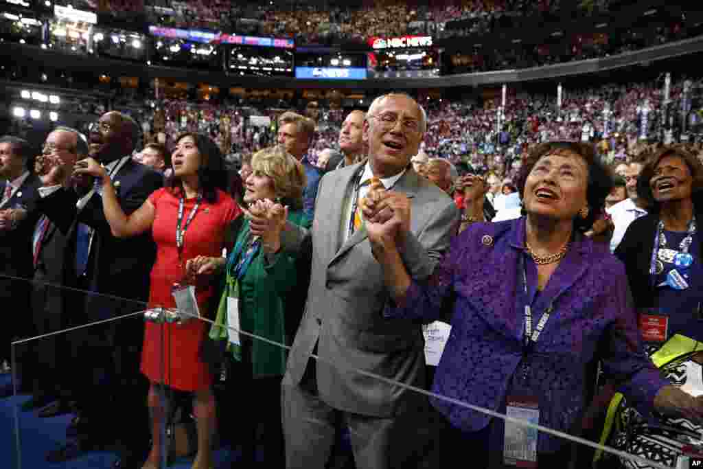 Rep. Nita Lowey, D-NY., right, Rep. Paul Tonko, D-N.Y., Rep. Louise Slaughter, D-N.Y., and other delegates sing along as entertainers sing "What the World Needs Now" during the third day session of the Democratic National Convention in Philadelphia, July 