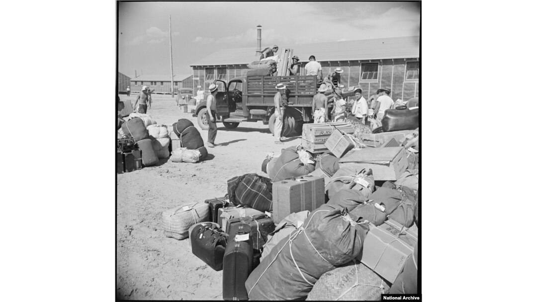 Baggage and luggage of Japanese-American internees newly arrived at the Minidoka camp from western Washington awaits delivery to their barracks in August 1942. (Francis Stewart, War Relocation Authority via National Archives)