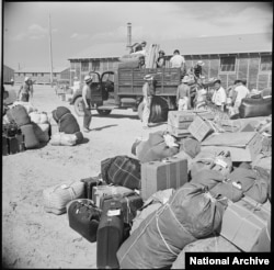 Baggage and luggage of Japanese-American internees newly arrived at the Minidoka camp from western Washington awaits delivery to their barracks in August 1942. (Francis Stewart, War Relocation Authority via National Archives)