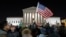 FILE - a protester waves an American flag in front of the Supreme Court during a protest about President Donald Trump's recent executive orders in Washington.