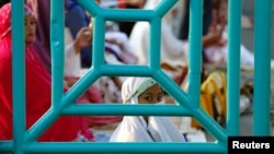 Seorang anak perempuan sedang mengikuti salat Ied Idul Adha di Jakarta, 12 September 2016. (Foto: Darren Whiteside/Reuters)