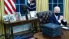 Biden family photos are displayed around a bust of activist Cesar Chavez, as U.S. President Joe Biden prepares to sign executive orders at the Resolute Desk inside the Oval Office of the White House in Washington, U.S., January 20, 2021. Picture taken Jan