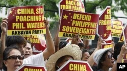 Protesters display placards during their rally outside the Chinese Consulate at the financial district of Makati city, east of Manila, Philippines, April 16, 2012.