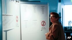 A voter checks a board on where to vote, at the Reykjavik City Hall polling station, during the general election in Reykjavik, Iceland, Oct. 28, 2017.