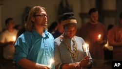 Lily Reagan and Kenneth McCarroll pray at Cathedral Guadalupe in Dallas, in honor of the police officers slain Thursday.