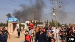 FILE - Palestinian families fleeing Gaza City and other parts of northern Gaza towards the southern areas, walk along a road on November 10, 2023 amid ongoing battles between Israel and the Palestinian Hamas movement.