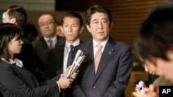 Japan's Prime Minister Shinzo Abe, center, speaks to reporters about the hostage crisis in Tokyo, Jan. 21, 2015. (AP Photo/Shizuo Kambayashi)