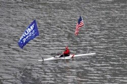 A person rows a boat flying a "Trump 2020" banner and the United States flag during the outbreak of coronavirus disease (COVID-19) in New York City, New York, March 30, 2020.