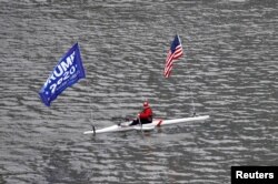 A person rows a boat flying a "Trump 2020" banner and the United States flag during the outbreak of coronavirus disease (COVID-19) in New York City, New York, March 30, 2020.