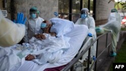 Healthcare workers push a patient into a less intensive unit from the Covid-19 Unit at United Memorial Medical Center in Houston, Texas on July 2, 2020. - Despite its renowned medical center with the largest agglomeration of hospitals and research laborat