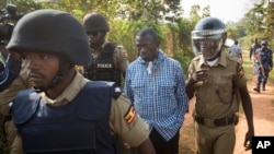 Uganda's main opposition leader Kizza Besigye, center, is arrested by police and thrown into the back of a blacked-out police van which whisked him away and was later seen at a rural police station, outside his home in Kasangati, Uganda Monday, Feb. 22, 2016.