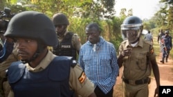 Kizza Besigye, l'opposant ougandais, candidat malheureux à l’élection présientielle, au centre, arrêté par des policiers à Kasangati, Ouganda 22 février 2016. 