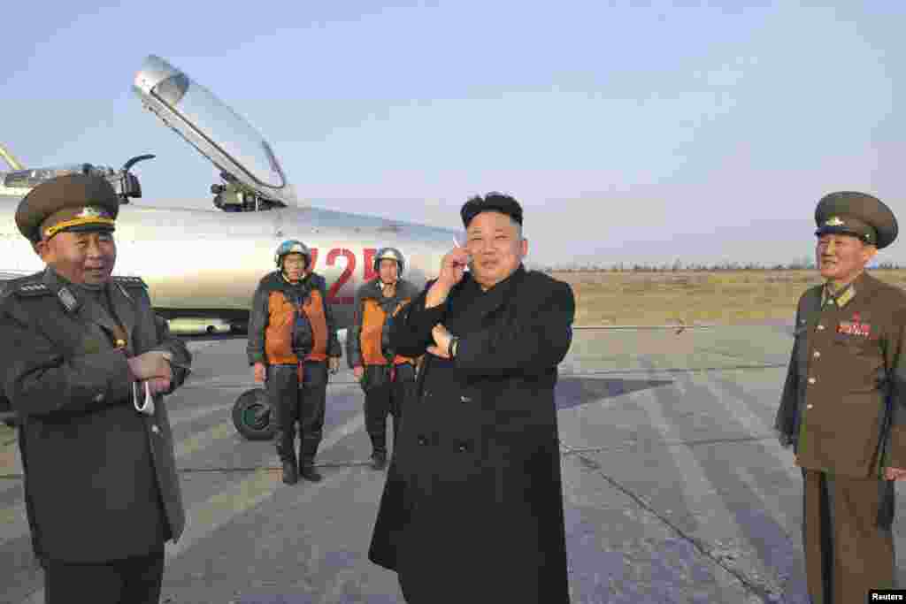 Lãnh tụ Bắc Triều Tiên Kim Jong Un hút thuốc trong lúc chờ đợi để quan sát một cuộc tập luyện của Ðơn vị Không quân 188.