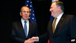 FILE - U.S. Secretary of State Mike Pompeo, right, shakes hands with Russia's Foreign Minister Sergey Lavrov as they meet on the sidelines of the Arctic Council Ministerial Meeting in Rovaniemi, Finland, May 6, 2019.