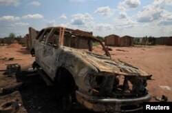 A burnt-out car is seen in Kapende, a Congolese neighborhood of Lucapa, Angola, Oct. 19, 2018.