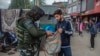 Tentara India tampak mengecek isi tas dari seorang pemuda Kashmir yang berjalan melewati area sibuk di pasar di Srinagar, wilayah Kashmir yang dikontrol oleh India, pada 11 Oktober 2021. (Foto: AP/Mukhtar Khan)
