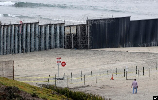 Concertina wire partially lines the border wall separating Tijuana, Mexico, behind, and San Diego, Nov. 19, 2018, in San Diego.