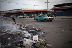 A man sifts through trash and scavenge for food outside a flea market in Maracaibo, Venezuela, May 14, 2019.