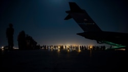 In this image provided by the U.S. Air Force, an aircrew prepares to load qualified evacuees aboard a C-17 Globemaster III aircraft as part of evacuation efforts at Hamid Karzai International Airport, in Kabul, Afghanistan, Aug. 21, 2021.