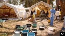 FILE - Health workers attend to patients suffering from cholera symptoms at a local hospital in Harare, Tuesday, Sept, 11, 2018. 