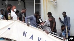 Photo d'archives (29 mai 2016): Des migrants débarquent du navire Vega de la marine italienne, à Reggio de Calabre, au sud de l'Italie, après avoir été secourus en mer Méditerranée au large des côtes de la Libye.