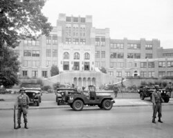 In this Sept. 26, 1957, file photo, members of the 101st Airborne Division take up positions outside Central High School in Little Rock, Ark., after President Dwight D. Eisenhower ordered them into the city to enforce integration at the school.