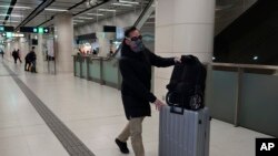 Un pasajero usa una máscara protectora y gafas al entrar en el metro en Hong Kong, el martes 28 de enero de 2020.
